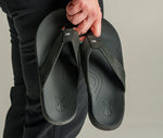 Detail of a man carrying his KALA 2.0 sandals by KURU Footwear in his hands
