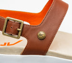 Close-up of the buckle on the KURU Footwear GLIDE Women's Sandal in WalnutBrown-BloodOrange