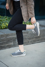 Woman showcasing her Dove Gray-Pale Lime FLEX Via WIDE sneakers by KURU Footwear while walking on the street in profile