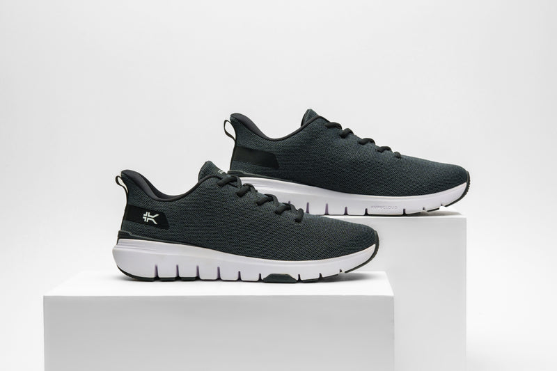 KURU Footwear FLEX Via WIDE sneakers in Jet Black-Bright White viewed from the side, presented on two white cubes