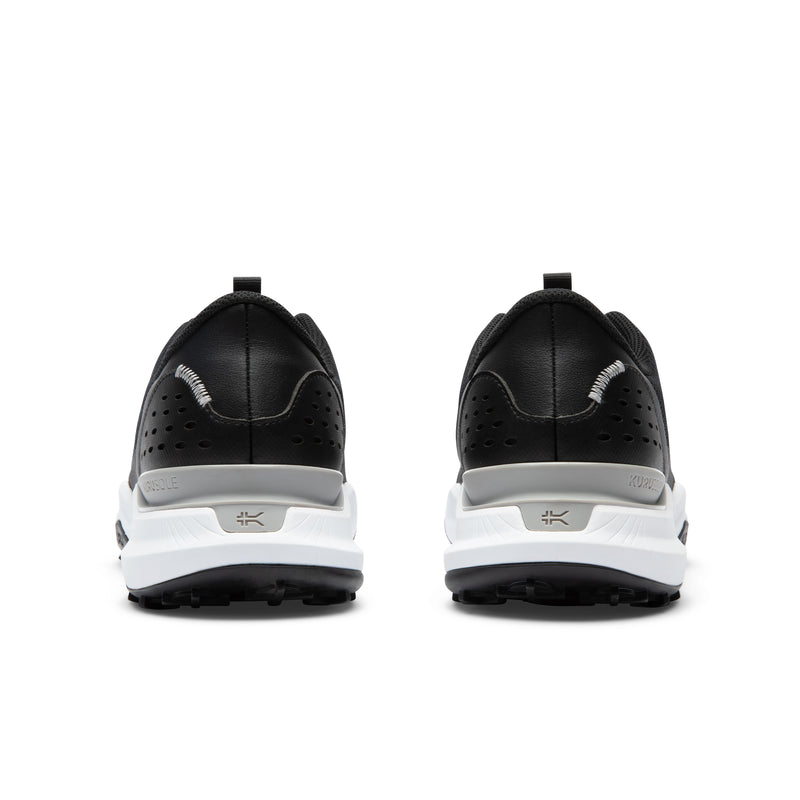 Black and white golf shoes with cleats on a white background