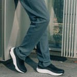 Person wearing KURU ATOM 2 Slip On Men's Sneaker in Jet Black Bright White.