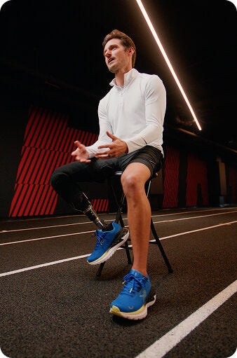 Paralympic athlete Jarryd Wallace sitting in blue KURU running shoes, sharing his customer story.