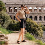 Woman walking near the Colosseum wearing KURU MOMENT Flip Women's Sandal in Jet Black.