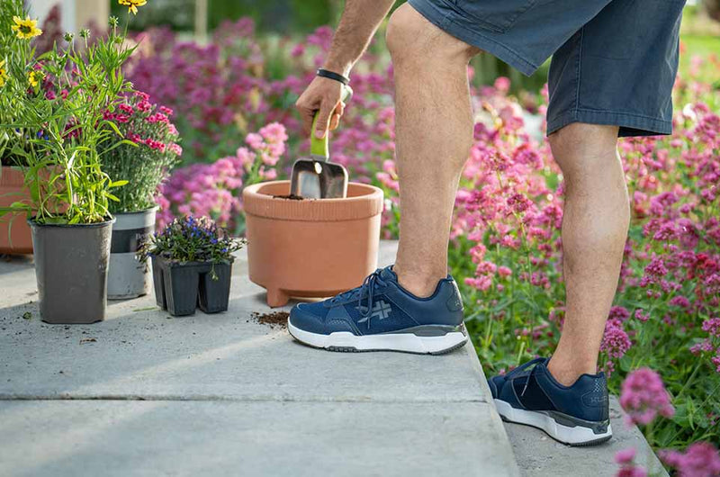 KURU Footwear man wearing QUANTUM shoe in color MidnightBlue while he is gardening
