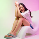 Woman sitting on a white chair with a colorful gradient background