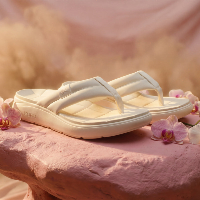 White sandals on a pink surface with pink flowers
