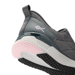 Gray athletic shoe with pink sole on a white background