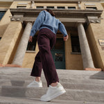Person walking up steps in front of a building with classical architecture